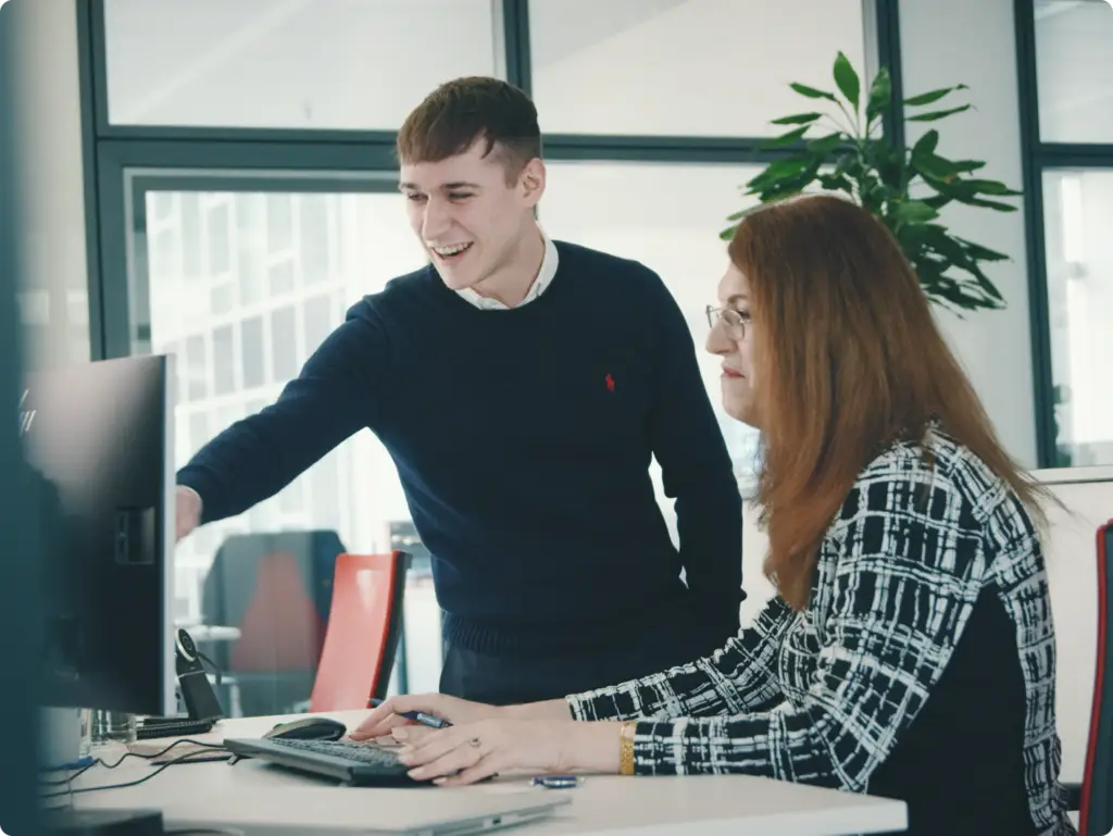 Zwei AKTIVBANK Kollegen schauen sich etwas auf dem Monitor an